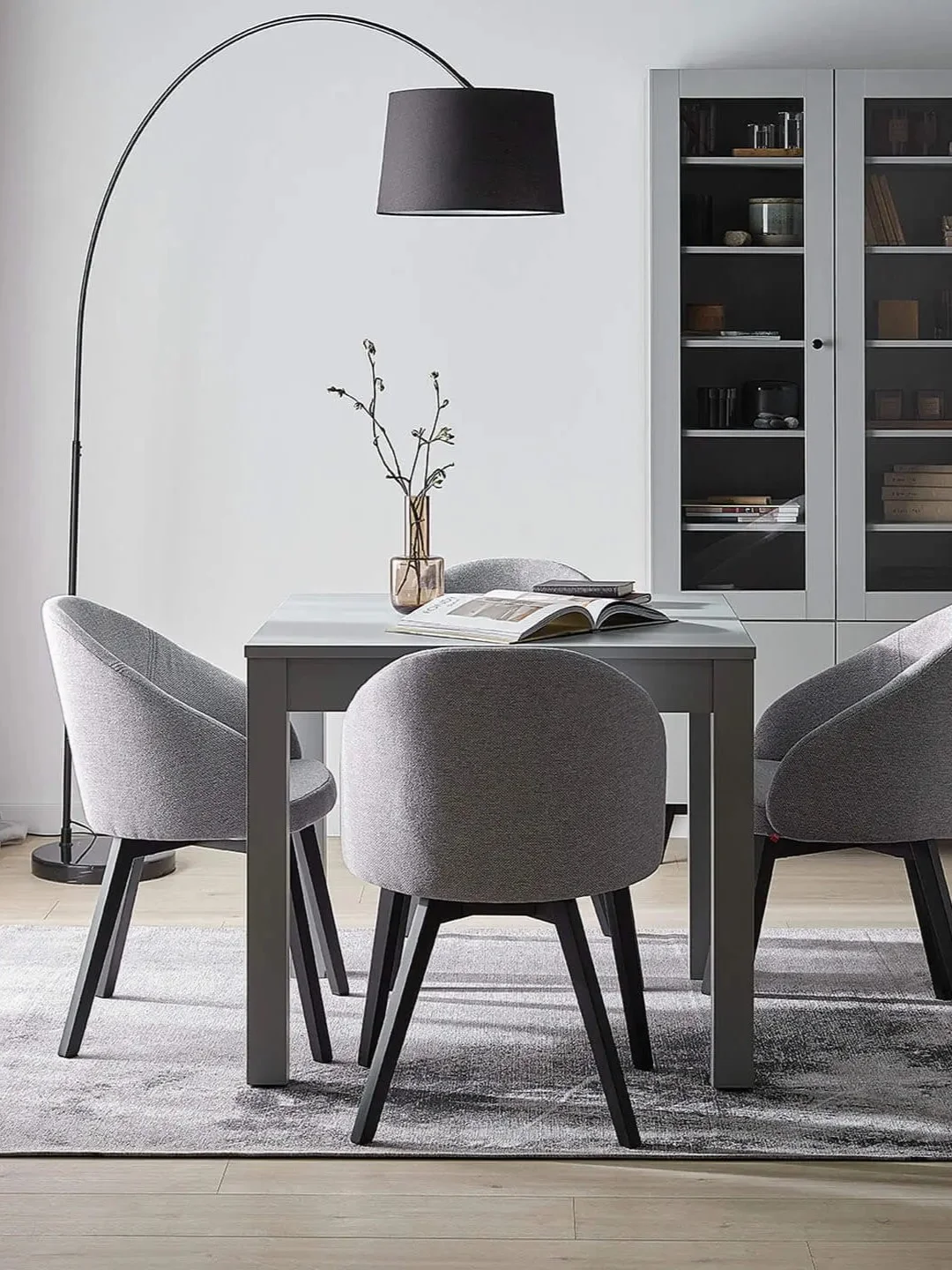 Lampa z dużym kloszem oświetlająca elegancką przestrzeń jadalnianą.